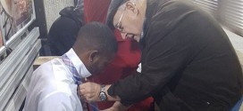 Image of couple teaching man how to tie his tie at Atlanta subway station